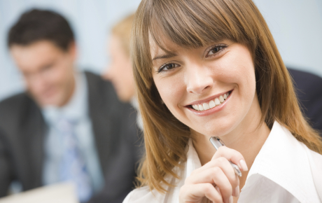 woman smiling with a pen on her chin